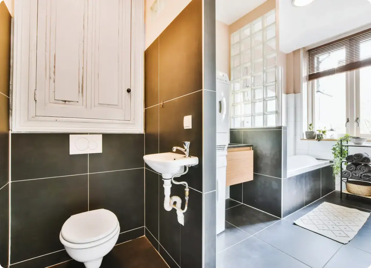 Koyu seramik kaplamalı, doğal ışık alan yenilenmiş banyo